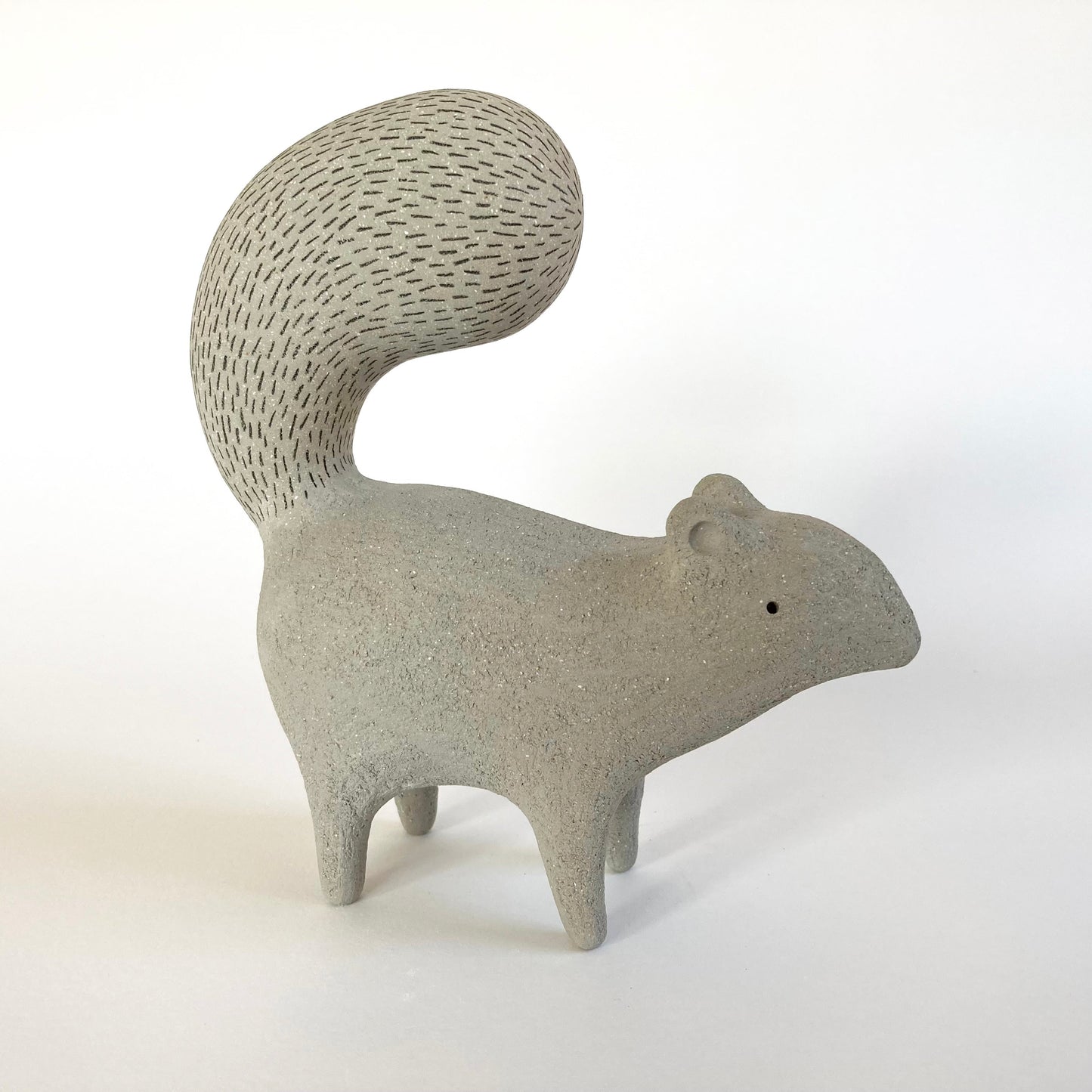 Ceramic squirrel figurine on a white background