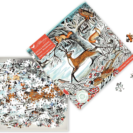 Packaging for Angela Harding Winter Wonderland 1000-piece jigsaw puzzle featuring a winter scene with deer, foxes, and birds in a woodland setting. The jigsaw packaging is open showing the contents of the jigsaw pieces.