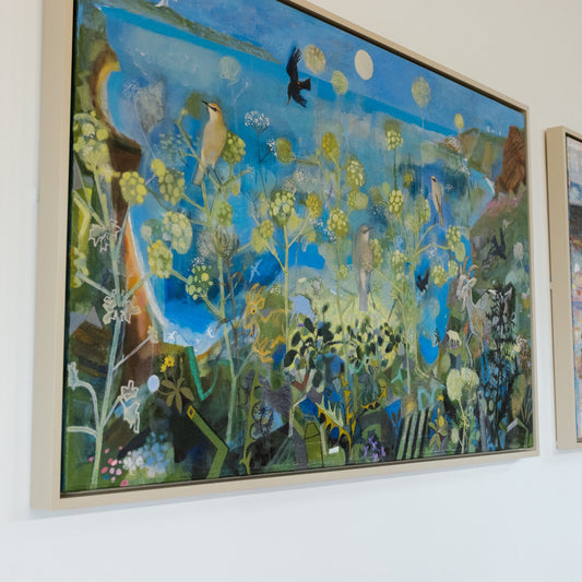 Artistic wall display with colorful paintings on a white wall