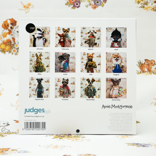 Back cover of a calendar featuring twelve images of whimsical animal figurines dressed in vintage clothing, each representing a month. The background has a floral pattern. The bottom includes branding and a barcode.