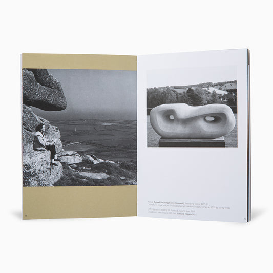 A book opened to a double-page spread. On the left, a black-and-white photograph of a person sitting on a rock, overlooking a landscape. On the right, a sculptural artwork displayed on a pedestal, also in black and white, set against a natural backdrop.