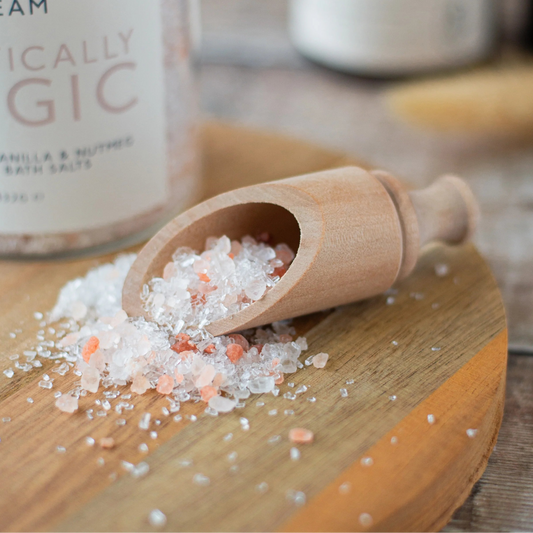 Salt and steam product with wooden scoop on a wooden surface.