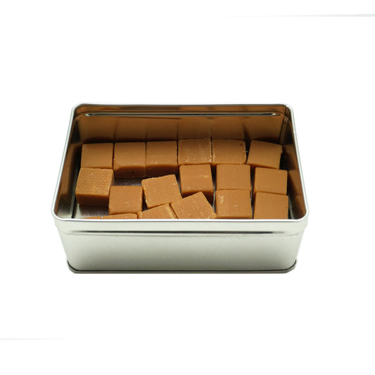 An open tin of individual square caramel sea salt chunks.