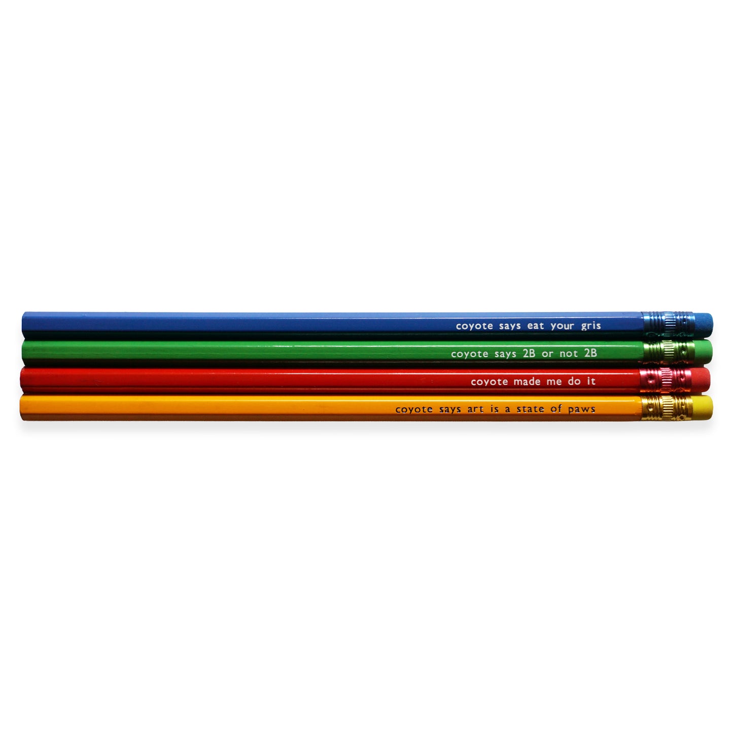 Four coloured pencils with humorous text: blue with "coyote says eat your gris," green with "coyote says 2B or not 2B," red with "coyote made me do it," and orange with "coyote says art is a state of paws".