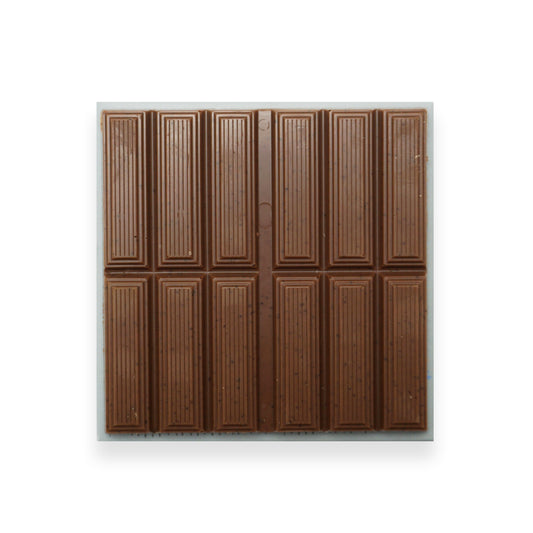 A square bar of milk chocolate sitting on a blue cardboard packet.