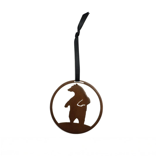 Decorative laser cut round metal ornament with bear silhouette on a plain white background, hanging from a black ribbon.
