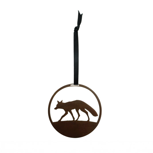 Decorative laser cut round metal ornament with fox silhouette on a plain white background, hanging from a black ribbon.