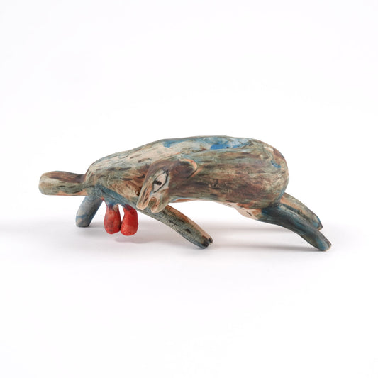 Small ceramic beaver whistle painted in browns and lues on a plain white background.