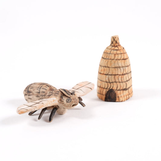 Ceramic painted bee and beehive whistle on a white background.