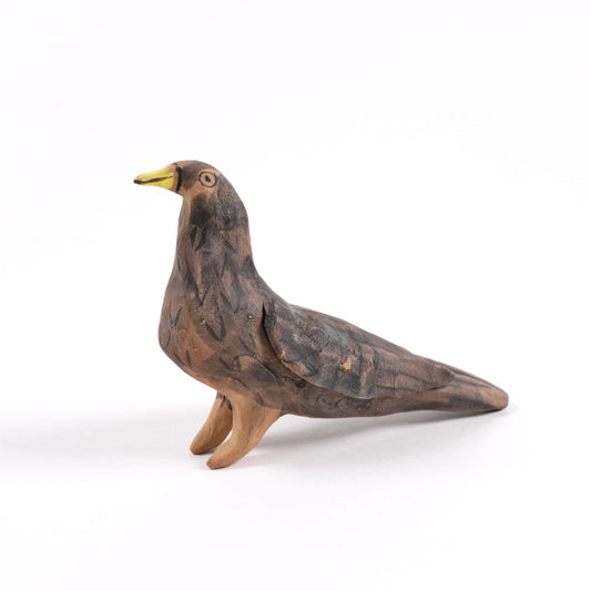 A painted ceramic blackbird whistle featuring a yellow beak and brown body shown on a plain white background.