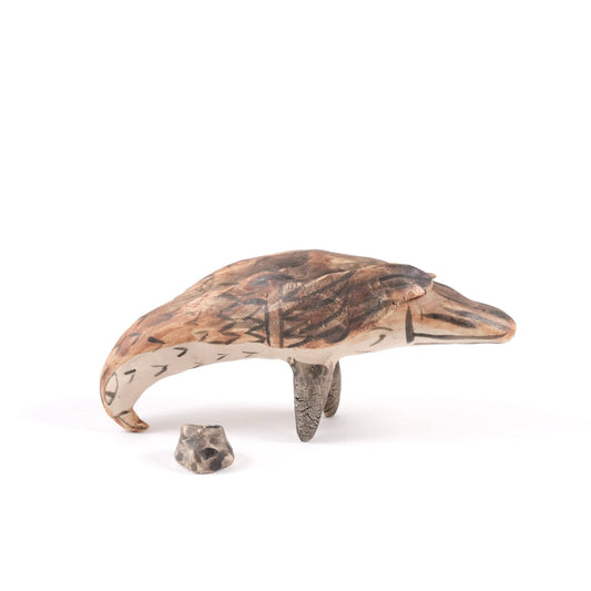 A painted ceramic eagle whistle in shades of brown and beige on a plain white background.