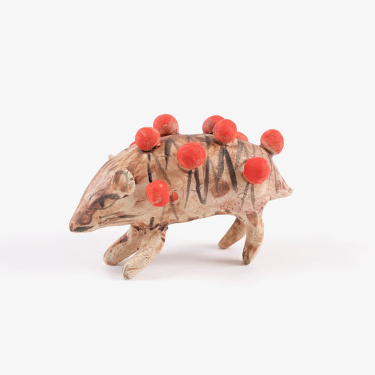 A painted ceramic hedgehog whistle in shades of brown with spherical red quills on a plain white background.