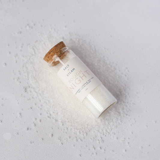 Glass jar with cork lid labeled 'Rough Night' on a textured white background