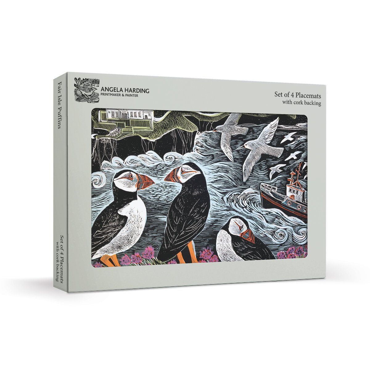 A boxed placemat set titled "Set of 4 Placemats with cork backing" by Angela Harding, shown at a slight angle on a light grey background. The front of the box features a detailed illustration of puffins, seals, waves, and a boat in black, white, grey, and small orange and pink accents.