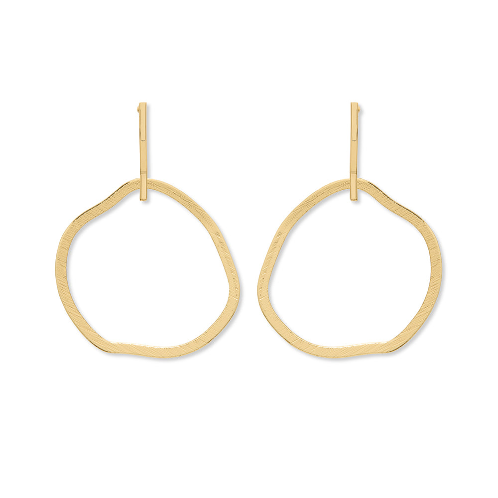 A pair of gold stud earrings featuring a large dangle circle hoop underneath.
