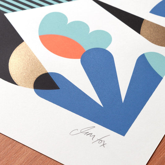 Abstract art print with geometric shapes on a wooden surface.