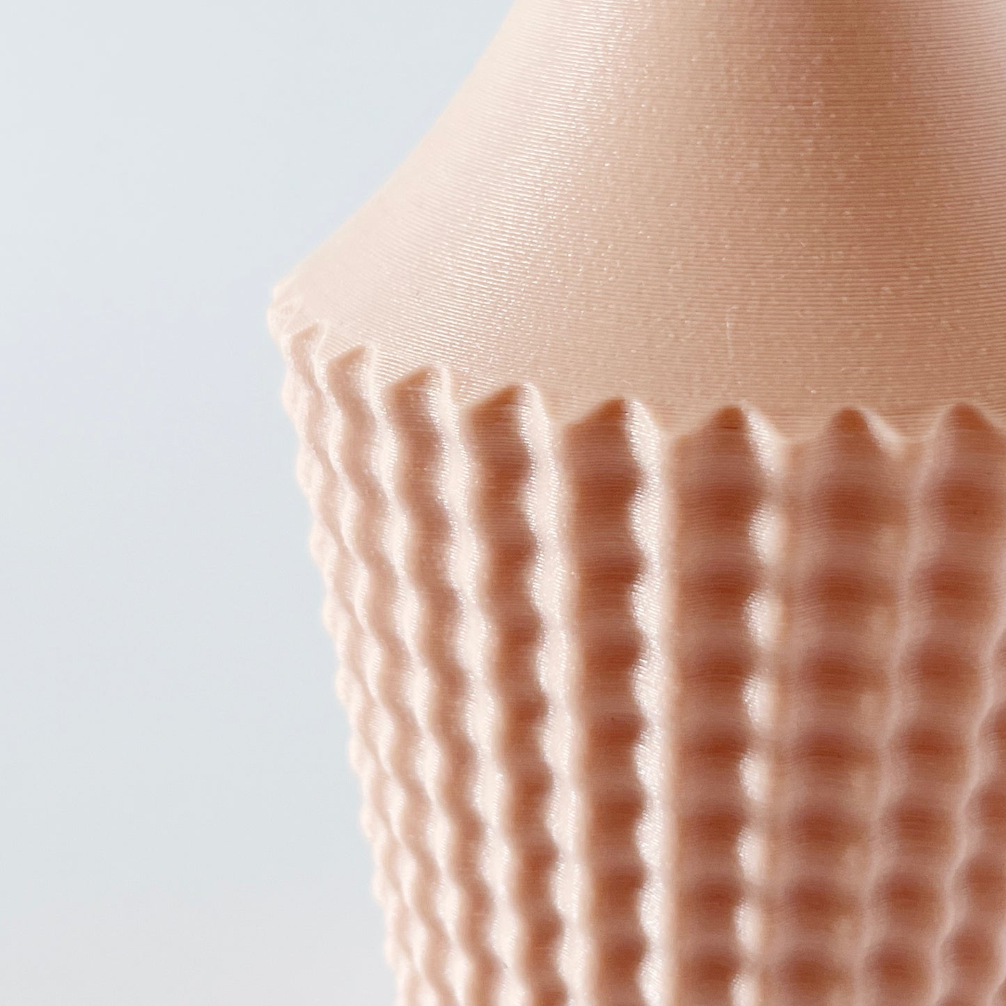 A close up showing the textured ribbed pattern on a 3D printed vase.