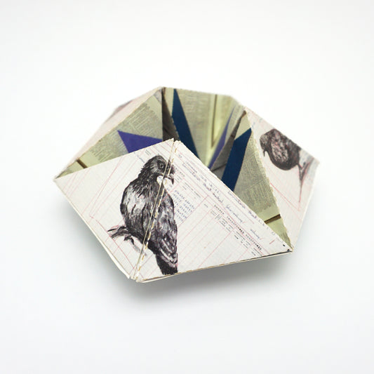 Geometric paper sculpture with geometric patterns on a white background