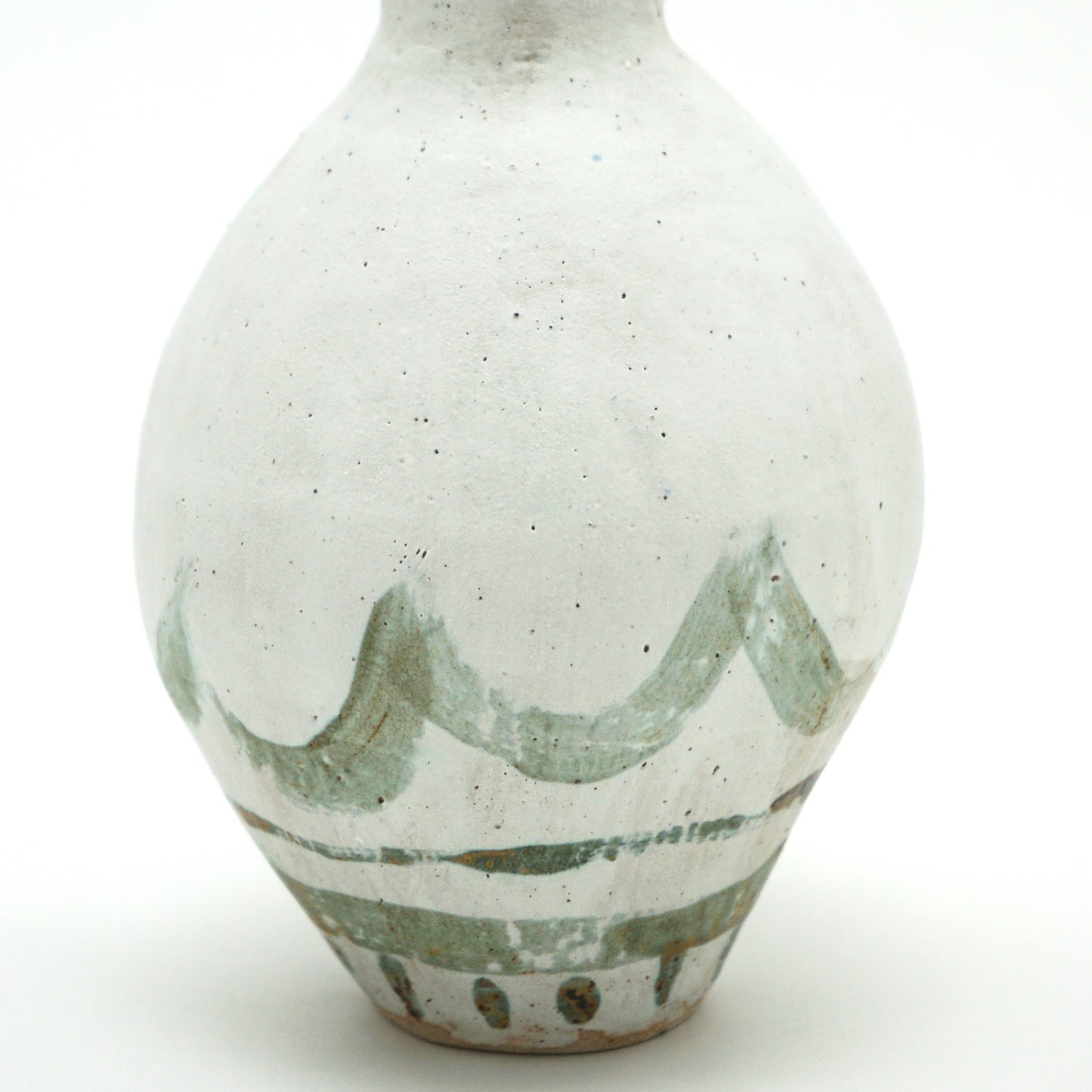 A close up shot of the markings on the white oval vase, the markings are swooping and abstract.