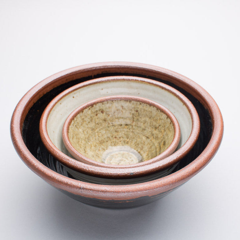 A set of three Leach Pottery bowls all stacked inside of one another.