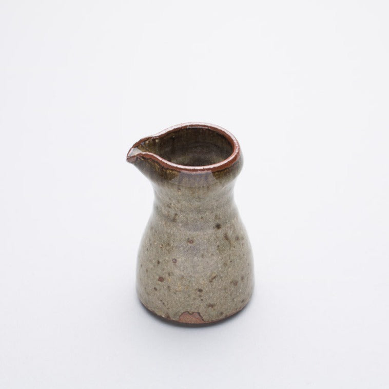 A ceramic pourer with a green to red-brown gradient ash glaze, reduction fired, from Leach Pottery.