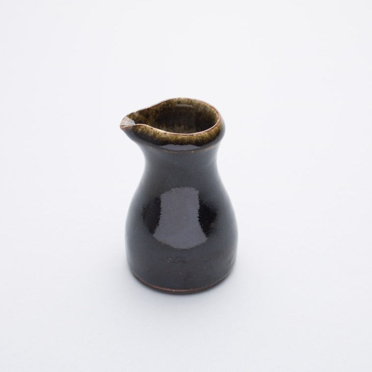 A ceramic pourer with a brown to black gradient ash glaze, reduction fired, from Leach Pottery.