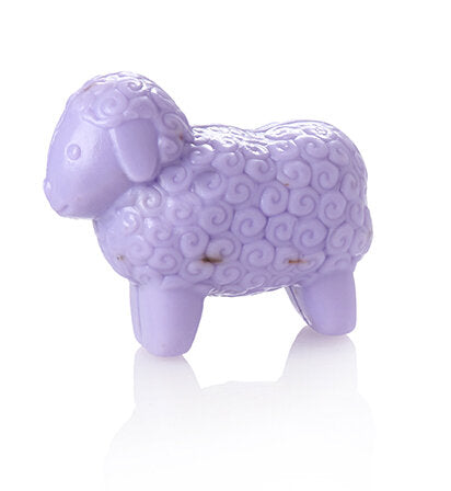 A purple sheep soap, crafted from a smooth material. The sheep has a textured body with swirling patterns, rounded ears, and a gentle expression. It stands on four short legs, reflecting light on a glossy surface.
