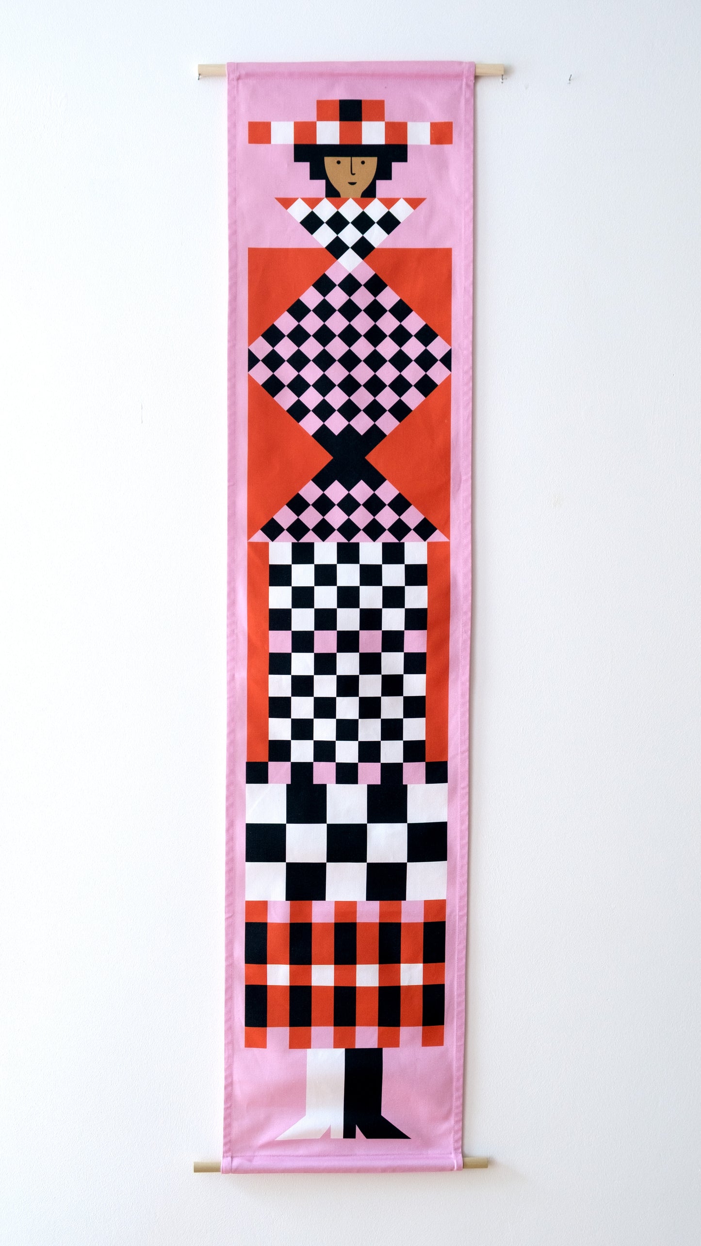 A fabric banner featuring a pink and red geometric figure with black and white accents.
