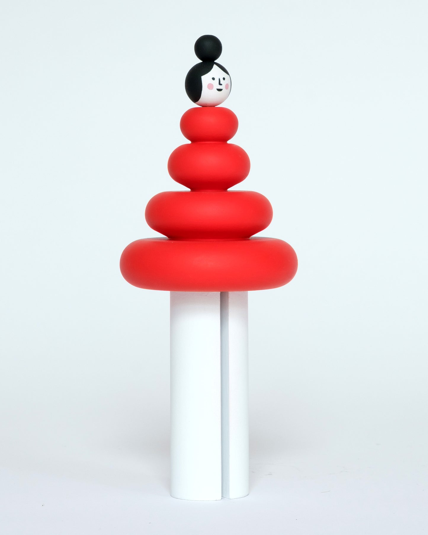 A red and white wooden figure, featuring a curved stacked body on a plain white background.