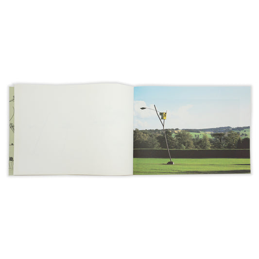 An open spread showing a blank page on the left and a full bleed image on the right. The image is of a sculpture in the landscape at YSP.