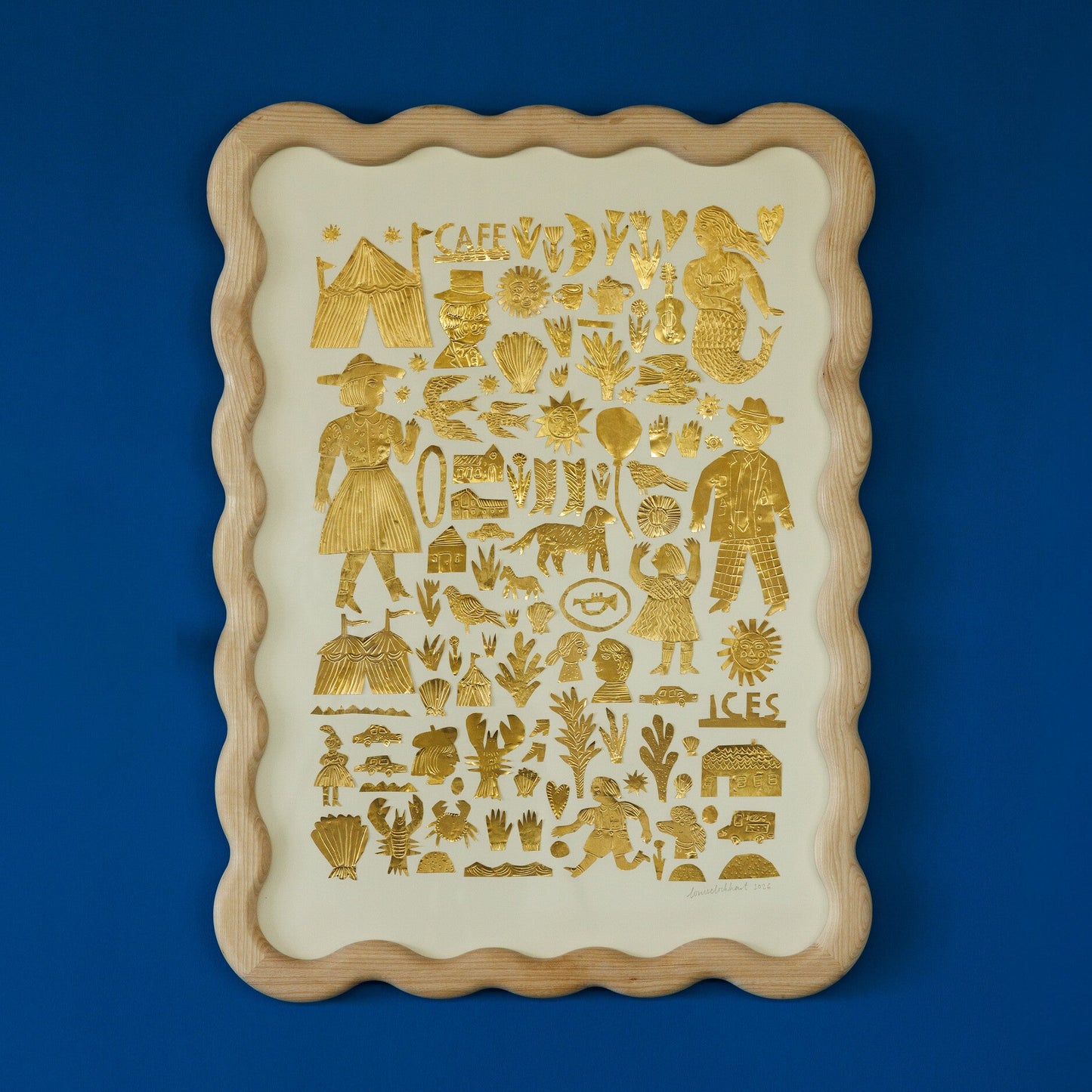 A decorative tray featuring a variety of gold illustrations on a cream background. The designs include people, animals, plants, and various symbols, all arranged in a grid pattern. The tray has a scalloped wooden frame and is set against a blue wall.