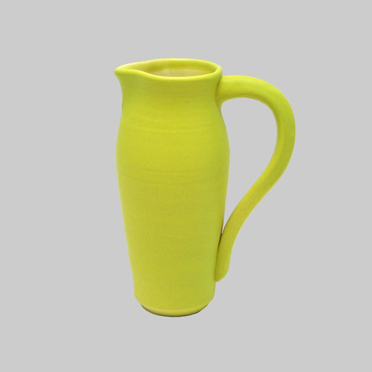 Green ceramic pitcher on a white background