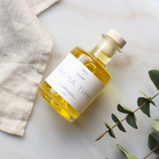 Bottle of 'Mama Time' oil with a label on a light background