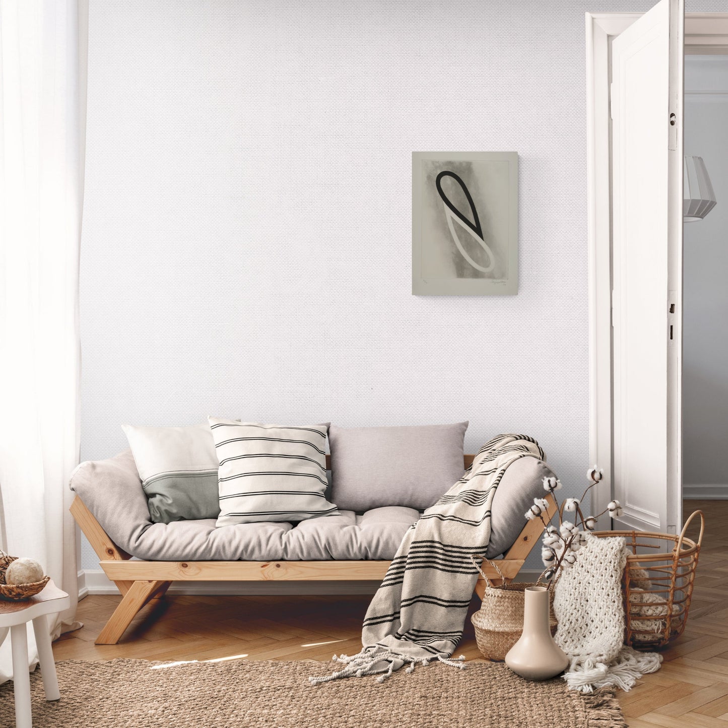 A light and airy living room featuring a wooden sofa adorned with cushions and a throw blanket. A woven rug lies on the floor, and a decorative basket sits nearby. A doorway leads to another room, with soft natural light streaming in.