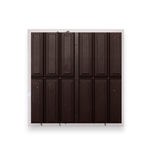 A bar of open dark chocolate sitting on a pink cardboard packet.