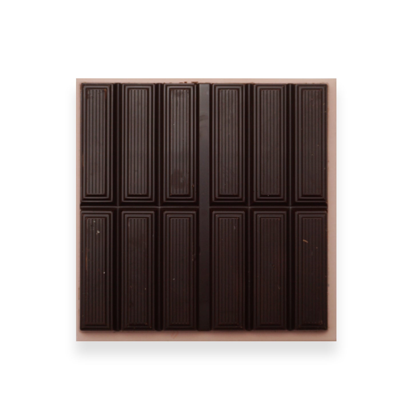An open bar of dark chocolate sitting on an orange cardboard packet.