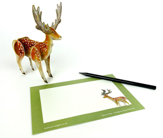 A three-dimensional pop-up card featuring a beautifully illustrated deer with antlers and a spotted coat, standing on a decorative base adorned with foliage. The card is set against a light green background.