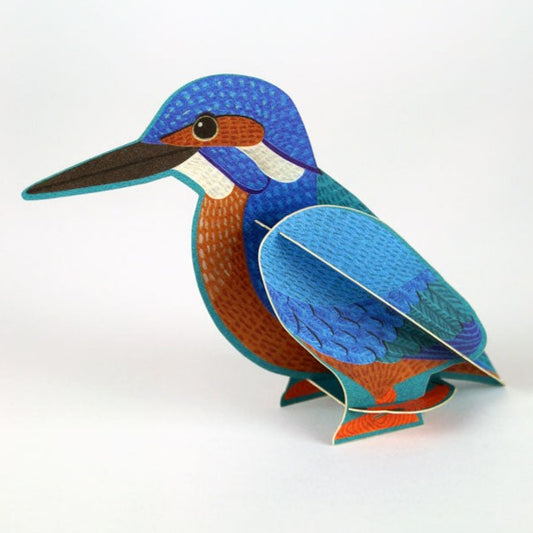 A vibrant, three-dimensional paper model of a kingfisher, featuring bright blue and orange colours. The bird is depicted in a side view, showcasing its detailed feathers and distinctive beak, set against a plain white background.