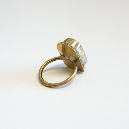 Gold ring with a textured band on a white background