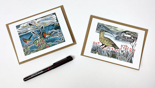 A set of notecards with matching envelopes, featuring two original prints of robins and teasels in a wintry landscape by print maker Angela Harding.