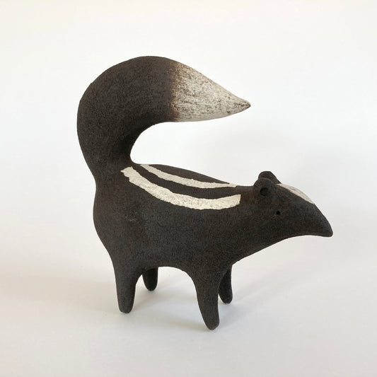 Stylized ceramic animal figure with a striped pattern on a white background