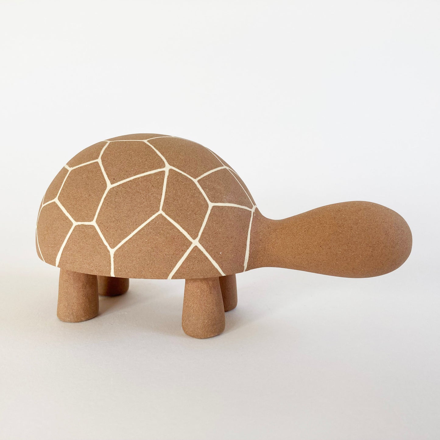 Ceramic tortoise with geometric pattern on a white background