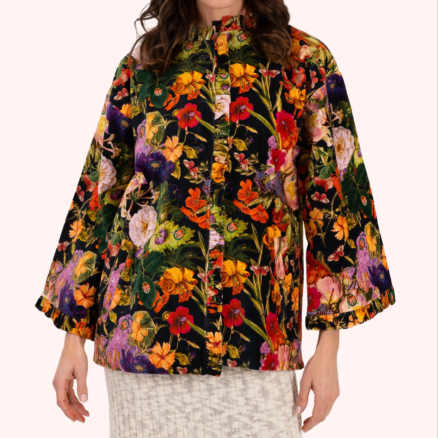 Woman wearing a colorful floral jacket on a white background