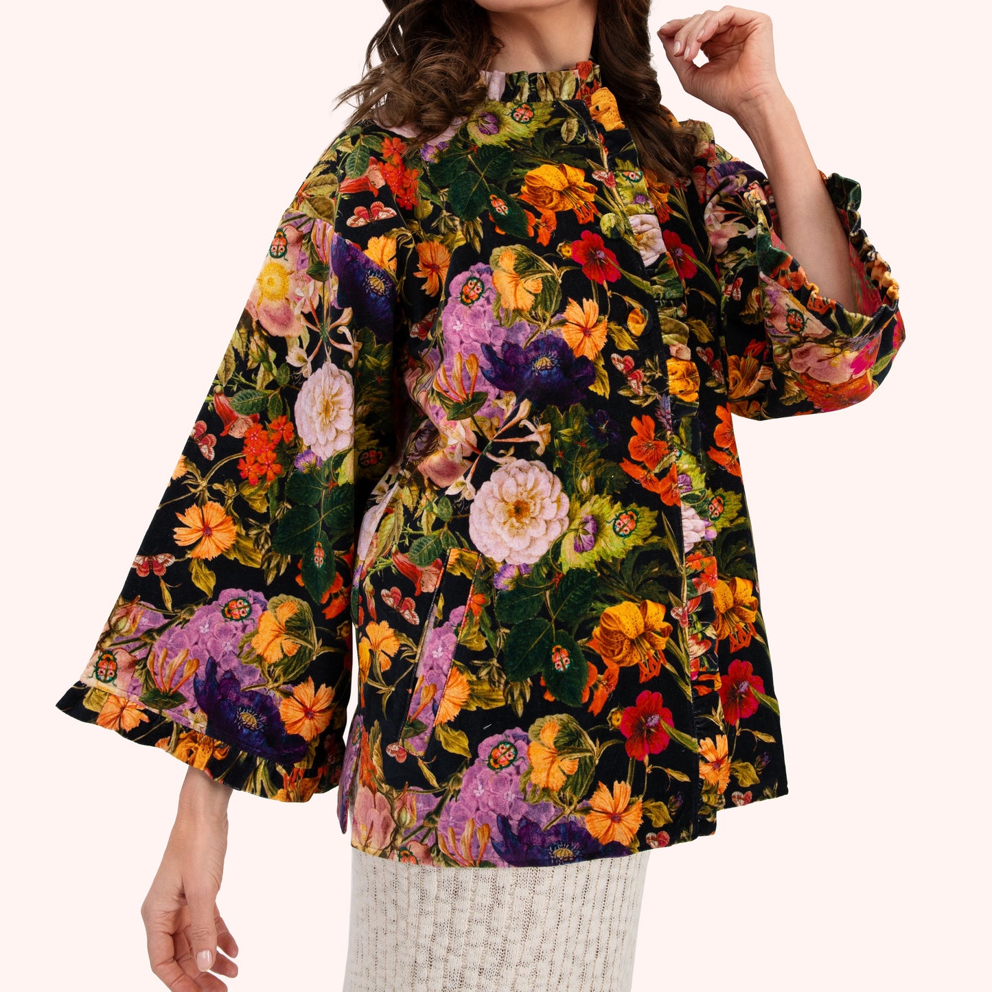 Woman wearing a colourful floral jacket on a white background