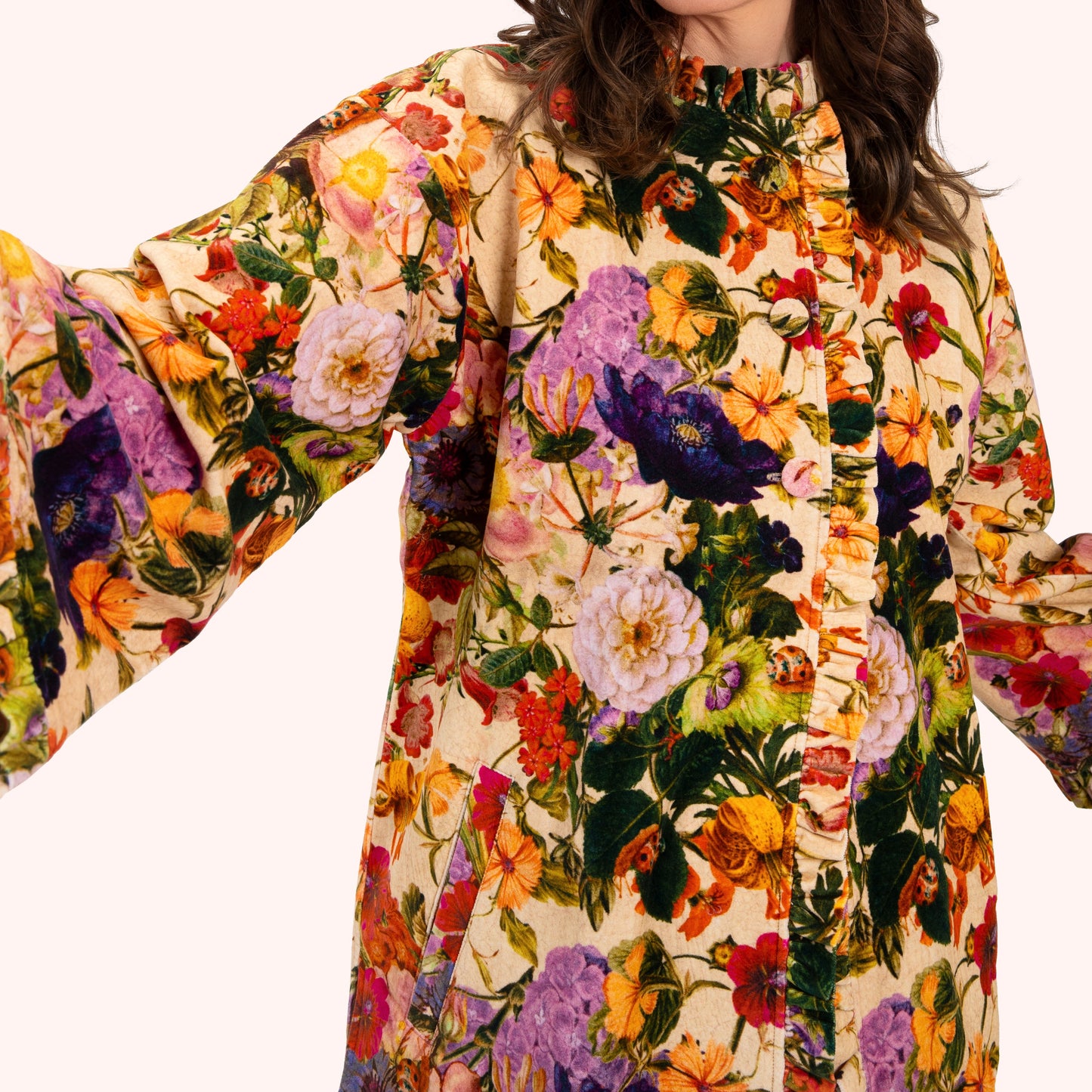 Woman wearing a colourful floral jacket on a white background