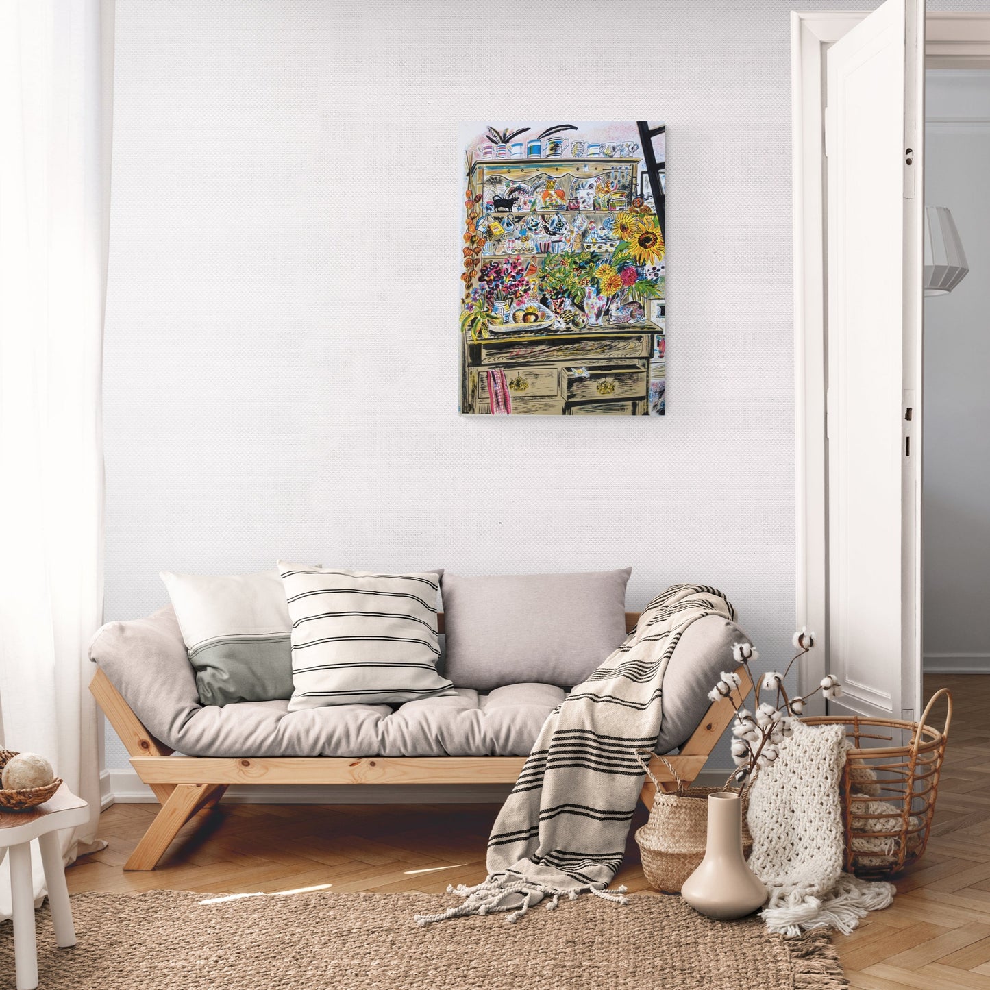 A lounge room with a grey sofa and cream blankets with a to scale screen print by Emily Sutton hung on the wall.
