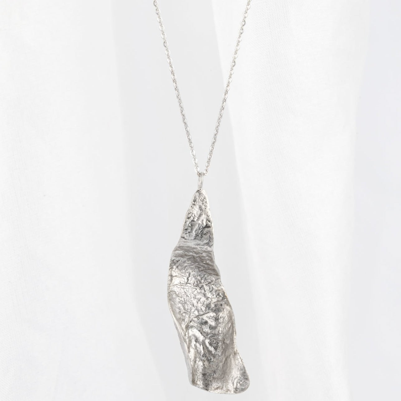 A silver textured pendant with a curled design on a chain, crafted from sterling silver.