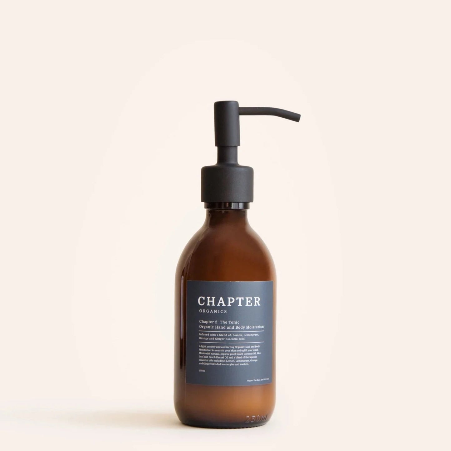 A brown glass bottle with a black pump dispenser, labelled "CHAPTER ORGANICS" in white text. The label features a description of the product and its benefits, set against a light beige background. The overall aesthetic is minimalist and elegant.