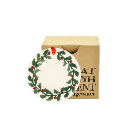 Circular decoration with holly design in a cardboard box on a white background