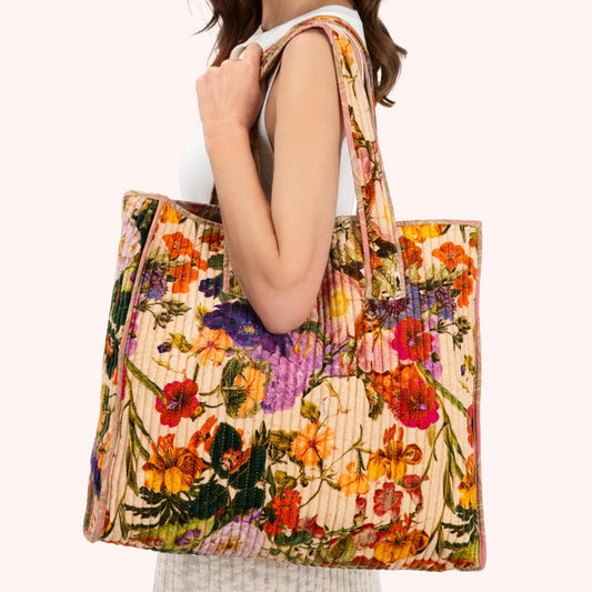Woman holding a colorful floral tote bag on a white background